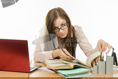 Image of Teacher looking for information in a book