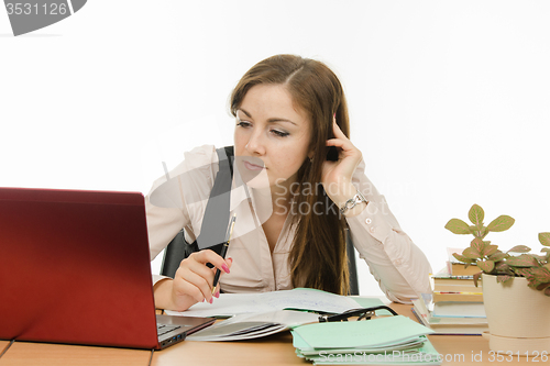 Image of The teacher looks intently at a laptop