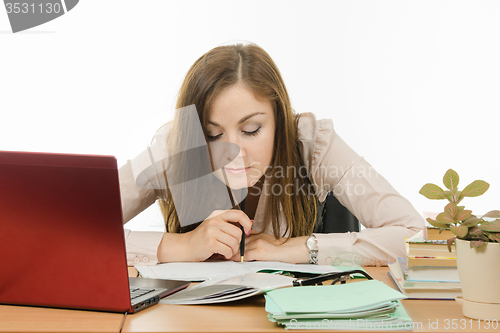 Image of The teacher carefully checks written in the notebook