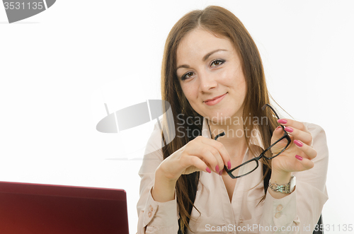 Image of The girl at the computer with the glasses in his hand