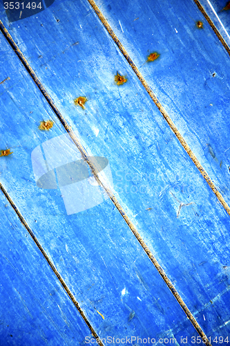 Image of dirty stripped  in the blue wood door and rusty nail