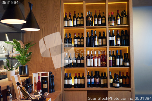 Image of Wine bottles on a wooden shelf.