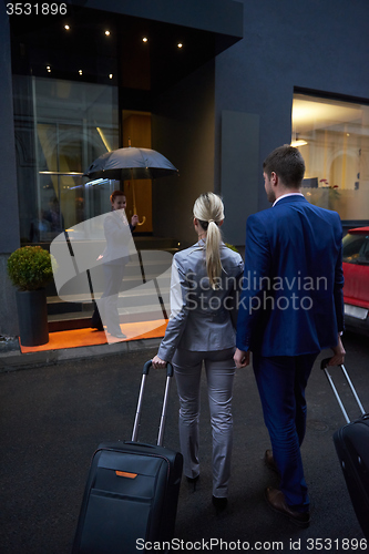 Image of business people couple entering  hotel