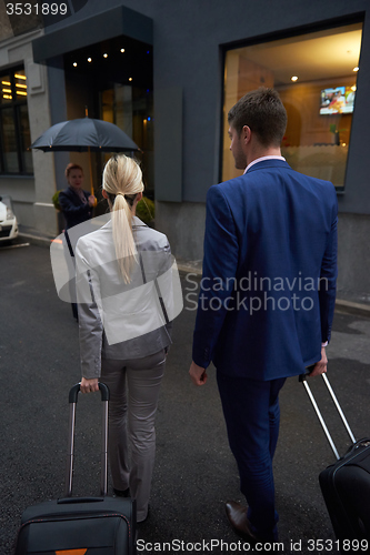 Image of business people couple entering  hotel