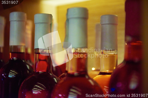 Image of Wine bottles on a wooden shelf.