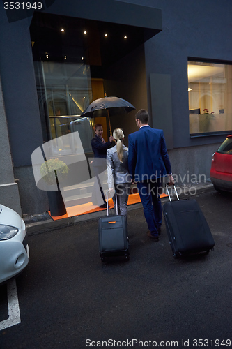 Image of business people couple entering  hotel