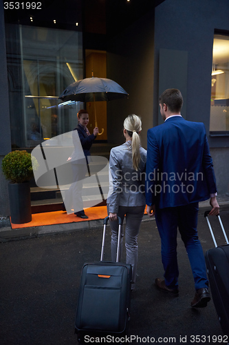 Image of business people couple entering  hotel