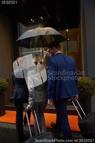 Image of business people couple entering  hotel