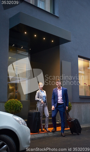 Image of business people couple entering  hotel