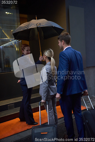 Image of business people couple entering  hotel