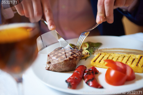 Image of business man eating tasty beef stak