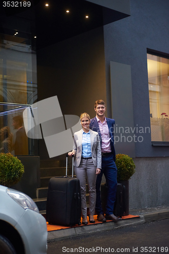 Image of business people couple entering  hotel