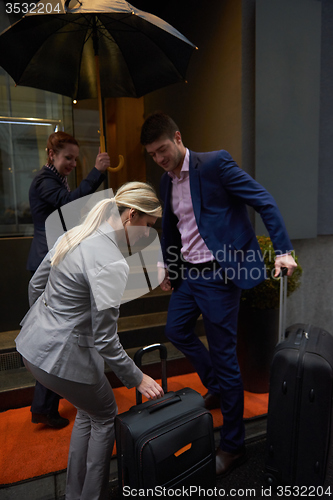 Image of business people couple entering  hotel