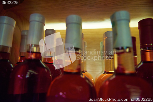 Image of Wine bottles on a wooden shelf.