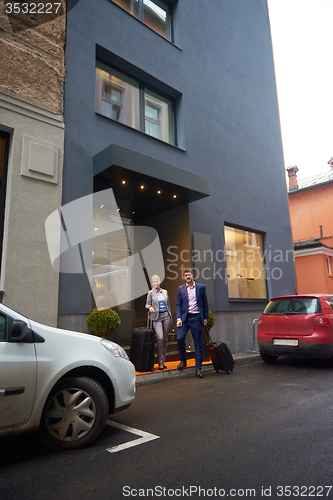 Image of business people couple entering  hotel