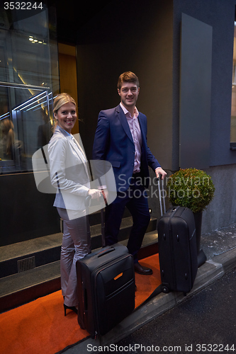 Image of business people couple entering  hotel