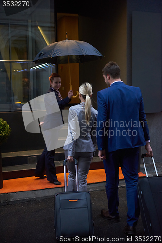 Image of business people couple entering  hotel