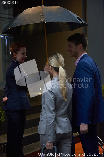 Image of business people couple entering  hotel