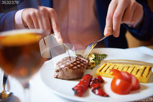 Image of business man eating tasty beef stak