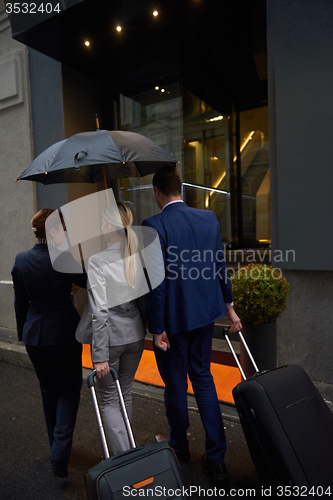 Image of business people couple entering  hotel