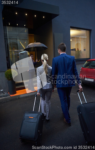 Image of business people couple entering  hotel