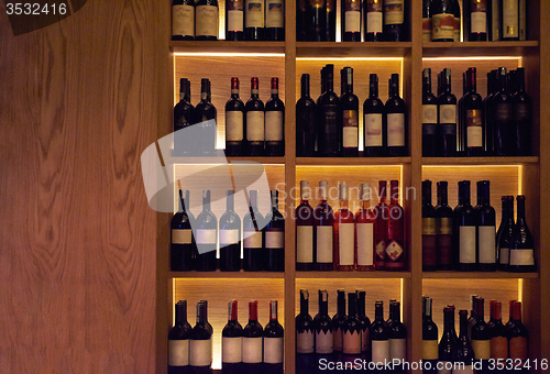 Image of Wine bottles on a wooden shelf.