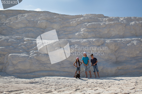 Image of Three children with dog on background of limestone wall of Pamuk