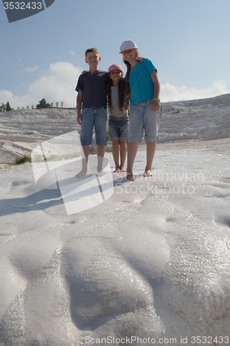 Image of Three children on background of limestone of Pamukkale, Turkey