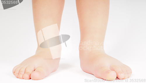 Image of Little person standing up barefoot towards bright background