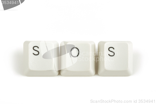 Image of SOS from scattered keyboard keys on white