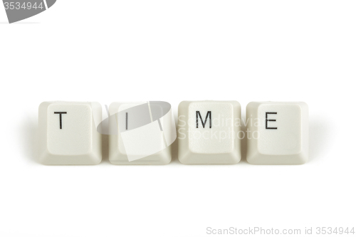 Image of time from scattered keyboard keys on white