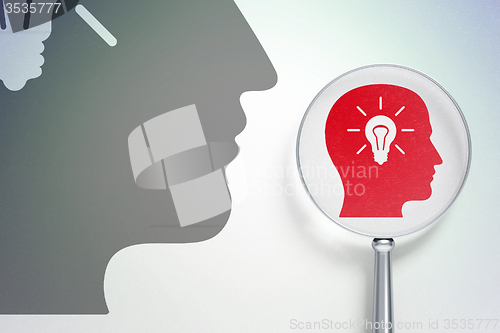 Image of Advertising concept:  Head With Light Bulb with optical glass on digital background
