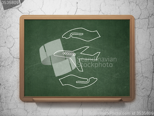 Image of Insurance concept: Airplane And Palm on chalkboard background