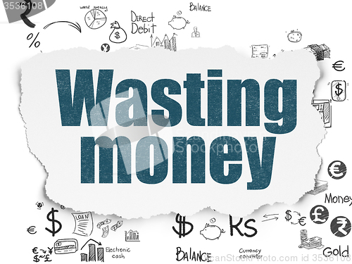 Image of Currency concept: Wasting Money on Torn Paper background