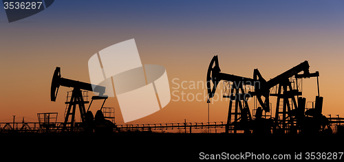 Image of Oil pumps on a oil field.