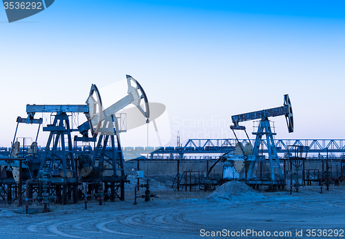 Image of Oil pumps on a oil field.