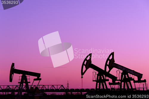 Image of Oil pumps on a oil field.