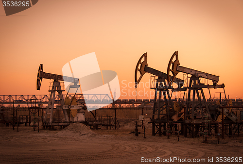 Image of Oil pumps on a oil field.