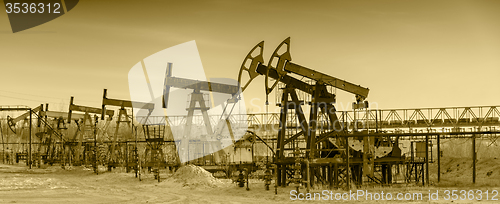 Image of Oil pumps on a oil field.