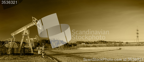 Image of Oil pumps on a oil field.