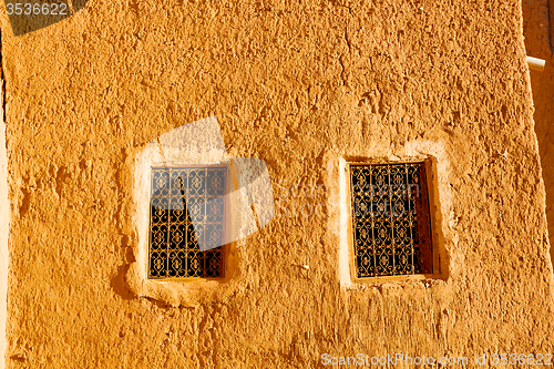 Image of   yellow window in construction and brown wall  