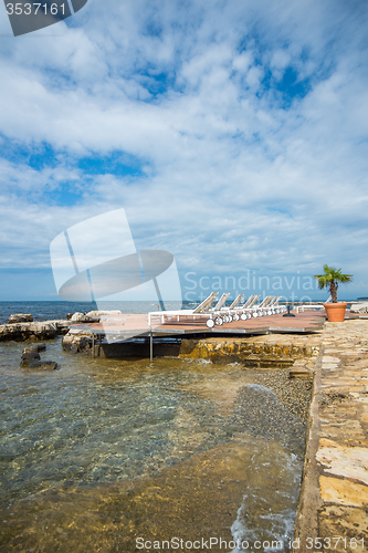 Image of loungers on the rocky beach