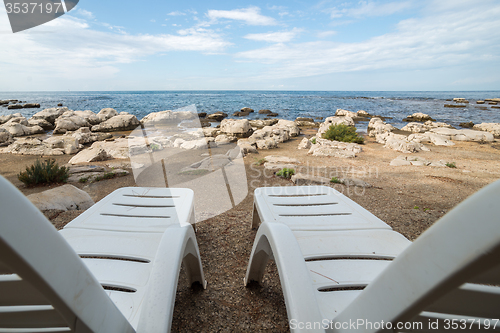 Image of loungers on the rocky beach