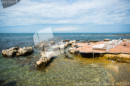 Image of loungers on the rocky beach