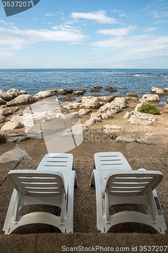 Image of loungers on the rocky beach