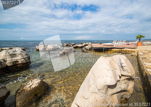 Image of loungers on the rocky beach