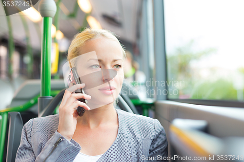 Image of Blonde business woman traveling by bus.