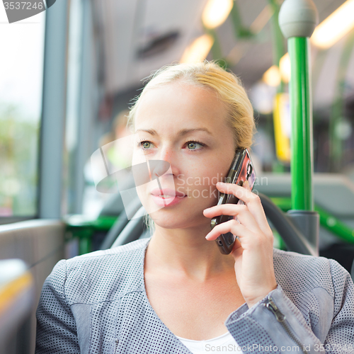 Image of Blonde business woman traveling by bus.