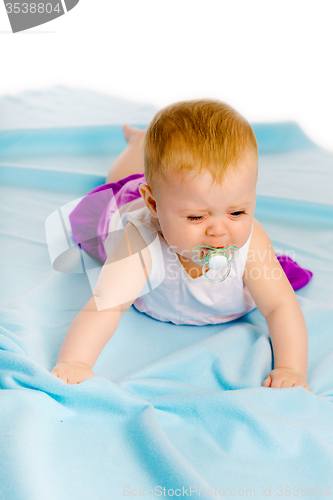 Image of baby girl with a pacifier crying. Studio