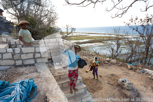 Image of Indonesian woman carries on hand basket with seaweed